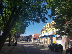 un coche aparcado frente a un edificio en una calle en Apartamenty PORTOWE en Ustka