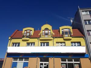 ウストカにあるApartamenty PORTOWEの赤屋根の黄色い建物