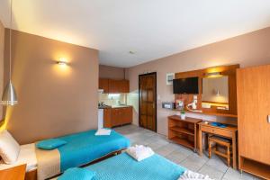 een hotelkamer met 2 bedden en een keuken bij Porto Marina in Chrysi Ammoudia
