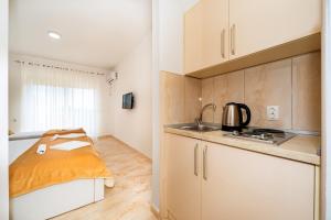 a kitchen with white cabinets and a bed in a room at Harasta Lux in Bar