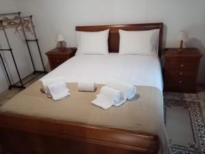 a bedroom with a large bed with two towels on it at Adega dos Virgilios in Madalena