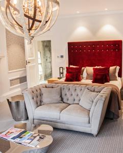 a bedroom with a couch and a large bed at Barnett Hill Hotel in Guildford