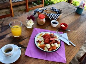 un tavolo con un piatto di cibo e un cesto di frutta di Hotel Descalzo a Zipolite