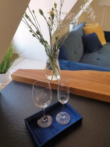 two wine glasses sitting on a tray on a table at Modernes Apartment an der Frauenkirche in Dresden