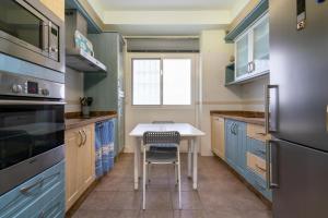 eine Küche mit blauen Schränken und einem Tisch mit einem Stuhl in der Unterkunft El Rincón de Triana in Almería