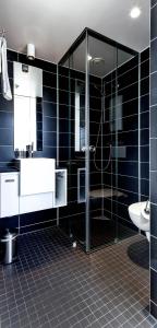 een badkamer met een douche, een wastafel en een toilet bij Hotel Wirtshaus Garbe in Stuttgart