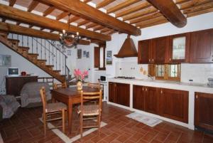 cocina y comedor con mesa y sillas en Agriturismo Ombianco en Seggiano