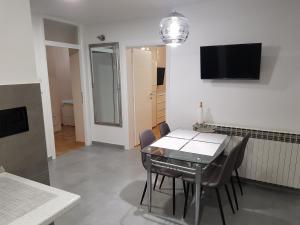 comedor con mesa, sillas y TV en Premium apartment, en Banja Luka