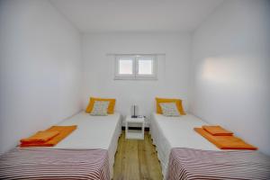 2 Einzelbetten in einem Zimmer mit Fenster in der Unterkunft casa do lago in Setúbal