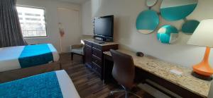 ein Hotelzimmer mit einem Bett und einem Schreibtisch mit Fernseher in der Unterkunft Howard Johnson by Wyndham Downtown Reno in Reno