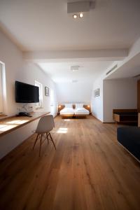 a large living room with a couch and a tv at Hotel Wirtshaus Garbe in Stuttgart