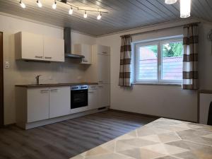 an empty kitchen with white cabinets and a window at Donisbauerhof in Lieserbrücke