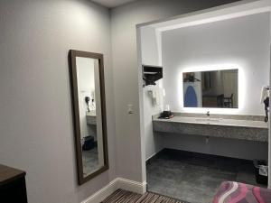a bathroom with a sink and a mirror at Palace Inn Crosby in Crosby