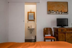 羅馬的住宿－波特加德爾阿蒂住宿加早餐旅館，一间卧室配有一张床、一台电视和一把椅子