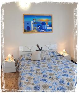 a bedroom with a blue and white bed with two lamps at Casa Vacanza Marina, in pieno centro a pochi passi dal mare e con aria condizionata! in Diano Marina