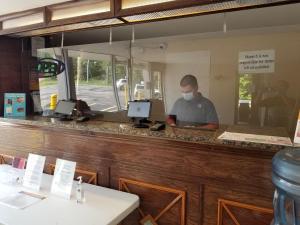 a man wearing a face mask at a bar at Motel 6 Morgantown in Morgantown