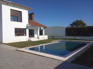 a swimming pool in a yard next to a house at Villa Madodos con piscina privada, jacuzzi, barbacoa y chimenea in Riofrío