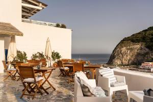 un patio con tavolo, sedie e vista sull'oceano di Casa al Sole Boutique Hotel a Ischia