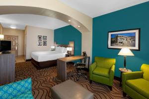 a hotel room with a bed and a desk and chairs at La Quinta by Wyndham Midland North in Midland