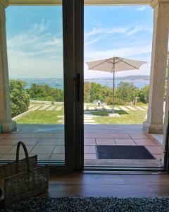 an open door to a patio with an umbrella at O Saramagal-Casa Nueva playa Area Brava - HIO in Hio