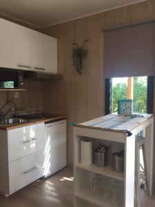 cocina con armarios blancos y encimera en La Cabane, en Draguignan