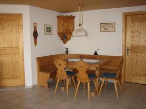 cocina con mesa de madera y sillas en una habitación en Er Liung - Ferienwohnung für max. 3 Personen, en Falera