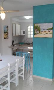 a kitchen with a white table and blue chairs at Praias Brancas. Boa Vida in Florianópolis