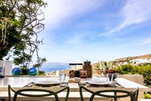 Triandáros的住宿－Tinos E-houses，一张桌子和椅子,享有海景