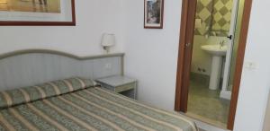 sypialnia z łóżkiem, umywalką i lustrem w obiekcie Gioia Guest House w Rzymie