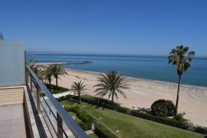 a view of a beach with palm trees and the ocean at Anacasa Atico Riu Bolulla Marenia AT1101 in Denia