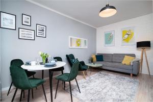a living room with a couch and a table and chairs at Apartament ProBaltica II Gdynia in Gdynia