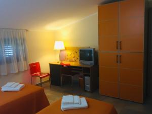a hotel room with a desk and a television at villa relax in Cepagatti