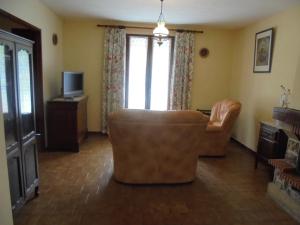 a living room with a couch and a television at Maison L'Acanaud in Malaucène