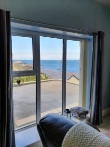 a room with a window with a view of the ocean at Atlantic Views Middle floor in Portrush