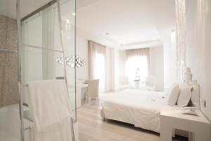 a hotel room with a white bed and white walls at Boscolo Nice Hotel & Spa in Nice