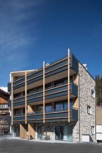 an office building with a stone and wood facade at Heislerhof Apartment in Mösern