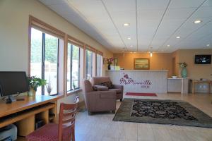 a lobby with a waiting room with a tv and chairs at McMinnville Inn in McMinnville