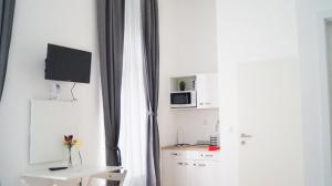 Habitación con escritorio, TV y ventana. en Brilliant 1BR Apt - Perfect for Longstays, en Viena