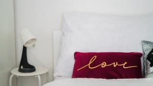 Una cama con una almohada roja con la palabra amor en ella en Brilliant 1BR Apt - Perfect for Longstays, en Viena