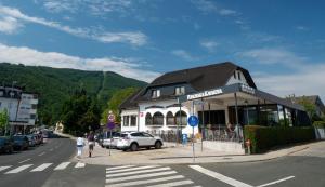 a building on the side of a street with a car at Guest House Pohorska Kavarna in Maribor