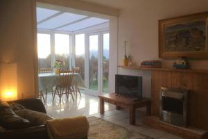 a living room with a fireplace and a table with chairs at Woodford Guest House in old farm in Killarney