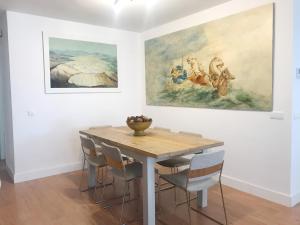 un comedor con una mesa y una pintura en la pared en Apartamento Rialto, en Málaga
