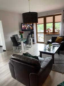 ein Wohnzimmer mit einem Sofa und einem Tisch in der Unterkunft Apartamenty Widok in Szczawnica