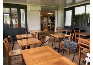 エオレにあるPremière Classe La Rochelle Sud-Aytréの木製のテーブルと椅子が備わる空きレストランです。