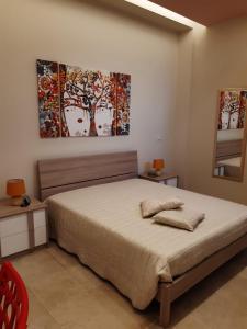 a bedroom with a bed and two paintings on the wall at Casa Pompelmo Rosa in Bernalda