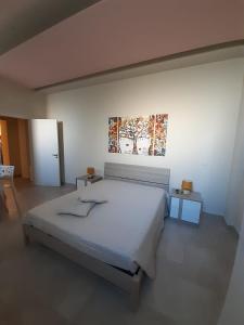 a bedroom with a bed and a painting on the wall at Casa Pompelmo Rosa in Bernalda