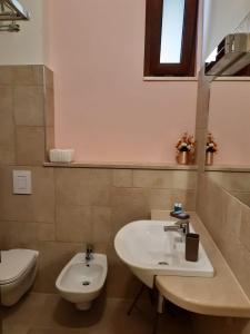 a bathroom with a sink and a toilet at Casa Pompelmo Rosa in Bernalda