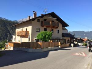 a white house with wooden balconies on the side of a street at Ferienwohnung EG Familie Meinschad in Rietz