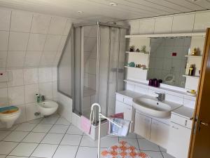 uma casa de banho com um chuveiro, um lavatório e um WC. em Pension Kunterbunt Büsum em Büsum