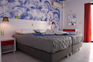 a bedroom with a large bed with a towel on it at Bouradanis Village Hotel in Marmari